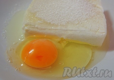 Творог смешать с сахаром и сырым яйцом, перемешать массу до однородности. Если любите сладкие сырники, тогда добавляйте 3 столовых ложки сахара, если нравятся сырники в меру сладкие - тогда кладите 2 столовых ложки.