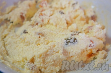 Добавить курагу и 2 столовых ложки муки к творожной массе, перемешать. Тесто для сырников должно получиться достаточно плотным, комковатым, из него будет легко слепить округлый сырник. Если же тесто вышло жидковатым, тогда добавьте ещё 1 столовую ложку муки.