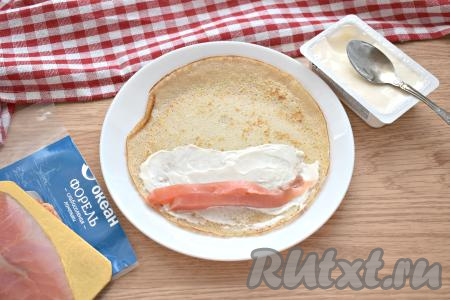 Слабосолёную форель нарезаем на полоски (или кусочки). Выкладываем кусочки форели поверх части блина, смазанной сыром.