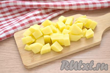 В кастрюлю наливаем 2 литра воды и доводим её до кипения. Нарезаем очищенную картошку на средние кубики и выкладываем в кастрюлю с закипевшей водой.