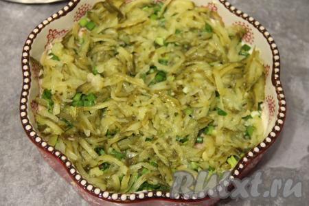 Маринованные огурчики натереть на крупной тёрке, отжать лишний сок. А затем равномерно выложить огурцы поверх лука.