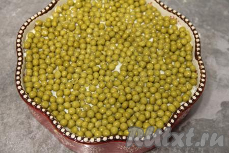 С горошка слить жидкость и выложить его ровным слоем поверх белков.