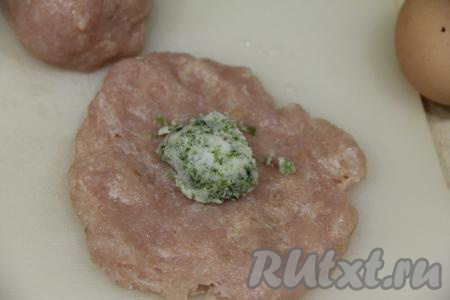 Сливочное масло комнатной температуры смешать с нарезанной зеленью и пропущенным через пресс зубчиком чеснока. Разделить масло на 4 части. Из каждой части фарша сформировать руками лепёшку и выложить в центр часть масла.