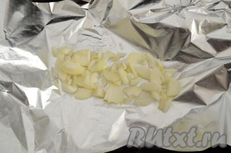 В форму для запекания выложить фольгу, на неё разложить 1/3 часть нарезанного лука.