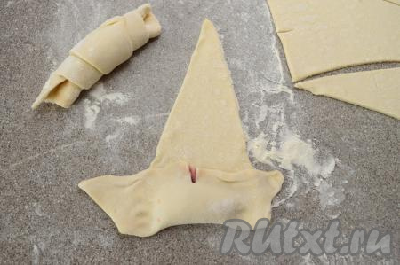 Накрыть начинку тестом, как на фото (надрез должен быть сразу за начинкой), аккуратно пальцами прижать тесто возле начинки, как бы закупоривая варенье в тесто со всех сторон (благодаря тщательному скреплению теста, варенье не будет вытекать из рогаликов). 