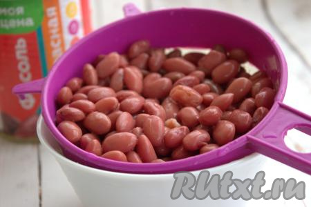 С красной консервированной фасоли слить жидкость, переложить в сито, промыть под проточной водой и оставить на несколько минут, чтобы стекла лишняя жидкость.