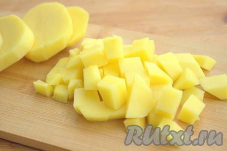 По истечении 25-30 минут вынуть из кастрюли части курицы, дать мясу немного остыть. Картошку вымыть, очистить, нарезать на небольшие кубики, добавить в бульон, дать закипеть, а затем варить картошку до полуготовности (минут 10) на небольшом огне.