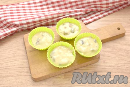 Получившееся тесто с шоколадом распределяем по силиконовым формочкам. Если вы для выпечки возьмёте другие формочки (например, железные), тогда смажьте их предварительно маслом. Формочки заполняем примерно на 2/3, так как тесто во время выпечки в духовке увеличится в объёме и поднимется. Из предложенного количества ингредиентов получается 12-14 кексов.