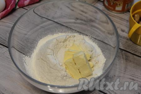 Охлаждённое сливочное масло (из холодильника) нарезать на кубики. Положить в сухие ингредиенты кусочки сливочного масла и перетереть массу руками в крошку.