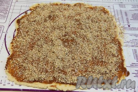 Смазать пласт теста сверху варёной сгущёнкой и присыпать дроблёными орехами. Я предварительно измельчила орехи в измельчителе.