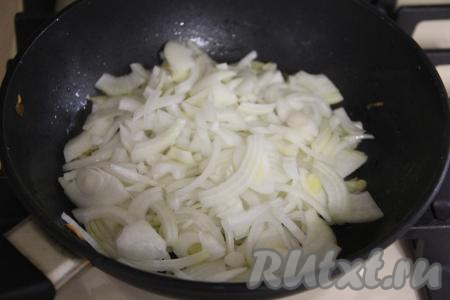В сковороде прогреть растительное масло, выложить лук, нарезанный на полукольца, обжарить его на растительном масле в течение 5-6 минут (до прозрачности) на среднем огне, периодически помешивая.