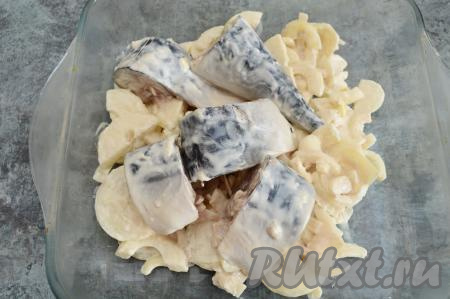 В форму для запекания выложить сначала кусочки лука в майонезе, а затем сверху разместить кусочки скумбрии (лук с поверхности рыбы я убираю).