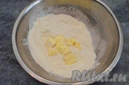 Муку, разрыхлитель, крахмал и сахар всыпать в глубокую миску и перемешать сухие ингредиенты столовой ложкой до однородности. В получившуюся смесь выложить холодное сливочное масло, нарезанное на кусочки.