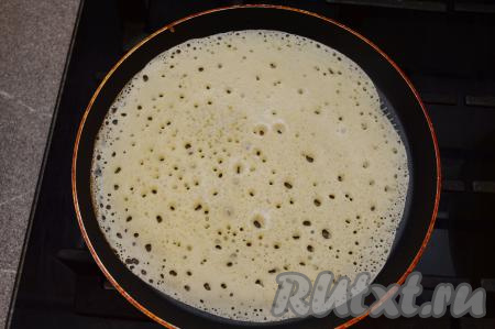 Заварные блины, замешанные на кефире и молоке, жарить на хорошо разогретой сковороде. Перед выпечкой первого блина я обычно смазываю сковороду маслом, а затем уже смазываю сковородку в процессе жарки по необходимости. На сковородку, прогретую с маслом, влить половник теста, равномерно его распределяя (тесто очень хорошо растекается). Поверхность блинчика сразу начнёт покрываться ажурными дырочками. Жарить блин до подрумянивания снизу и до "схватывания" теста сверху на среднем огне.