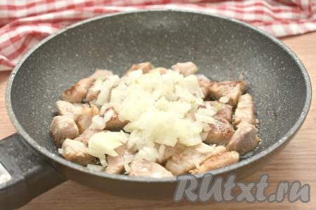 Очищаем лук и морковь. К обжаренной свинине выкладываем лук, нарезанный на небольшие кусочки, перемешиваем и обжариваем 2-3 минуты, иногда помешивая.