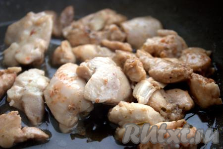 Влить растительное масло в глубокую сковороду, поставить на огонь. В разогретое масло выложить кусочки куриного мяса и обжарить их на среднем огне до появления золотистой корочки со всех сторон.