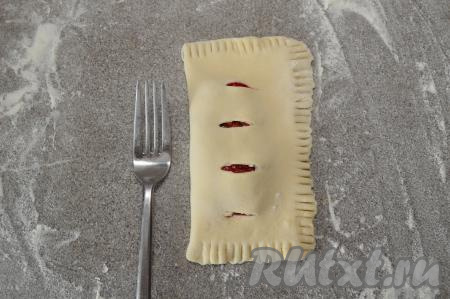 Стороной с разрезами аккуратно накрыть сторону с начинкой (надрезы окажутся сверху). При помощи вилки тщательно скрепить края слойки. Зубцы вилки лучше окунать в муку, тогда они не будут приставать к тесту.