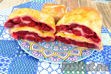 Готовый рулет из слоёного теста достать из духовки, дать ему остыть, чтобы начинка из вишни стабилизировалась. Остывшую выпечку нарезать на порционные кусочки и подать к столу. В этом рулете приятно сочетаются тесто и большое количество кисло-сладкой начинкой. Смотрите, какой яркий разрез у нашего рулета. Пить кофе, молоко или чай с этой сочной, вкусной выпечкой - одно удовольствие!