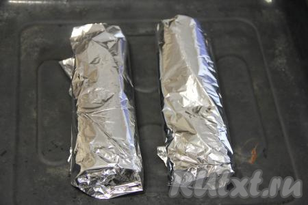 Завернуть рыбу с овощами в фольгу в виде плотного конверта. Аналогично завернуть в фольгу второго хека с оставшимися овощами. Выложить рыбу в фольге на противень.