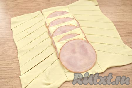 На свободных сторонах теста (слева и справа) делаем ножом косые надрезы (ориентируйтесь на фото).