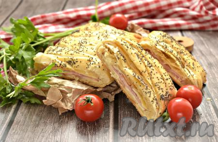 Достаём из духовки выпечку, немного остужаем, нарезаем на кусочки и с удовольствием угощаемся. Пирог из слоёного теста с сыром и ветчиной получается и сытным, и аппетитным, и вкусным, а готовится он совершенно просто. Попробуйте!