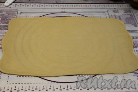 Тесто обмять и на присыпанной мукой поверхности раскатать в прямоугольный пласт толщиной 2-3 миллиметра.