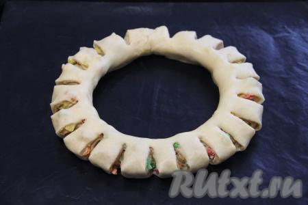 С помощью ножниц сделать по всему диаметру кольца не очень глубокие надрезы (надрезы должны быть примерно на половину ширины кольца). Оставить пасхальное кольцо в тепле на 35 минут.