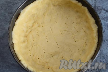 Дно разъёмной формы для выпечки (у меня форма диаметром 22 сантиметра) застелить пергаментом, бортик формы промазать сливочным маслом. Выложить тесто в форму.&nbsp; Разровнять тесто по дну формы, сделав небольшой бортик. Наколоть тесто вилкой.