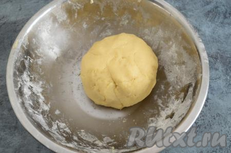 В получившуюся смесь масла и сметаны всыпать разрыхлитель, сразу начать частями добавлять муку, вмешивая её в тесто вначале ложкой. А затем, продолжая постепенно всыпать муку, замесить руками мягкое, очень приятное в работе, слегка липнущее к ладоням тесто. Добавляя муку, ориентируйтесь на консистенцию замешиваемого теста, а не на количество муки, указанное в ингредиентах. Песочное тесто, завернув в пищевую плёнку, убрать минут на 30 в холодильник.