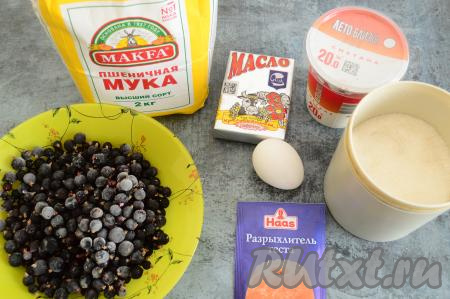 Подготовить продукты для приготовления пирога с чёрной смородиной и сметанной заливкой. Эта выпечка получается отличной и со свежей, и с замороженной чёрной смородиной. Свежие ягоды нужно промыть, отделить от веточек, обсушить. Замороженные ягоды чёрной смородины, если на них нет большого количества льда, можно не размораживать. Сливочное масло должно быть комнатной температуры, поэтому его нужно заранее достать из холодильника.