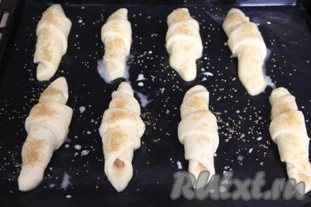 Смазать рогалики молоком и, по желанию, присыпать сахаром (у меня - тростниковый сахар).