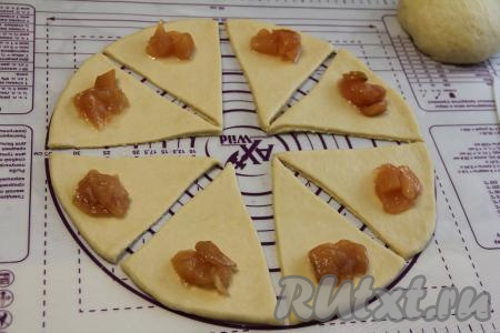 Выложить по 1 чайной ложке варенья (или джема, повидла) на широкий край тест, отступая от краёв секторов по 1 сантиметру. В качестве начинки я использовала&nbsp;яблочное варенье.