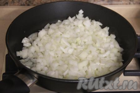 Отваренную куриную печень откинуть на дуршлаг и остудить. Почистить лук и морковку. Лук мелко нарезать, выложить в сковороду, уже прогретую с растительным маслом, и обжарить до золотистого цвета (в течение 4-5 минут), иногда помешивая, на среднем огне.