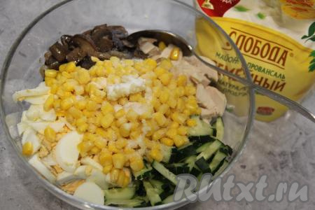 В этот же салатник выложить кукурузу без жидкости и пропущенный через пресс зубчик чеснок, посолить, перемешать.