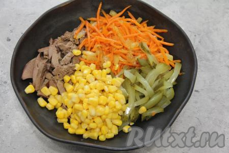 В салатнике соединить куриную печень, огурчик, кукурузу без жидкости и жареные лук с морковью, подсолить салат по вкусу (добавляя соль, учитывайте, насколько солёные огурцы вы используете).