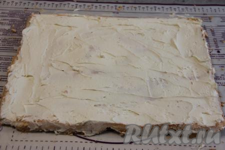 Смазать кремом всю поверхность тёплого меренгового коржа (если корж полностью остынет, он станет достаточно хрупким и его сложно будет сворачивать). Разрезать смазанный корж на 4 полоски шириной примерно 7,5 или 8 сантиметров.