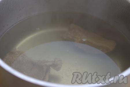 Вымытую говядину выложить в кастрюлю, влить 2-2,5 литра холодной воды, поставить на сильный огонь. Дать воде закипеть, уменьшить огонь до минимума, снять пену и варить говядину 60-70 минут.