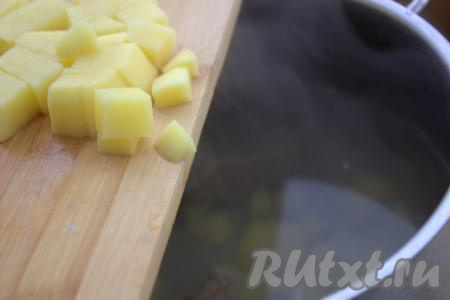 После того как мясо с перловкой проварятся 30 минут, достать готовую говядину из бульона, дать ей немного остыть. В кастрюлю с бульоном и перловкой выложить очищенную и нарезанную на средние кубики картошку, дать закипеть, а затем варить на небольшом огне минут 20 (до мягкости перловки и картофеля).