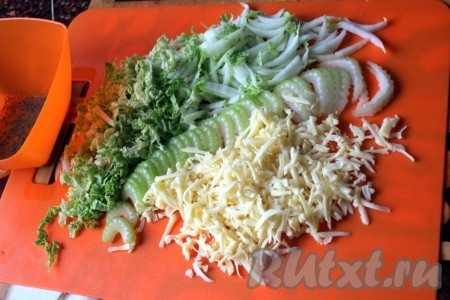 Китайскую капусту нашинковать, сельдерей нарезать поперек стебля, половину сыра натереть.