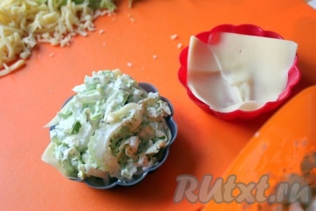 Для приготовления запеканки с сельдереем и китайской капусты в силиконовые формочки положить кусочки сыра, чтобы было закрыто дно и заполнить сырно-овощной массой.