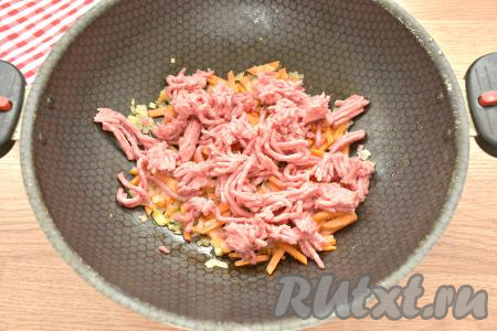 После этого выкладываем мясной фарш в сковороду. Обжариваем фарш с овощами 5-7 минут (до изменения цвета мяса), разбивая мясные кусочки лопаточкой.