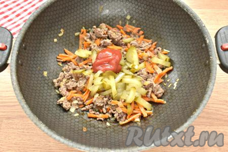 Далее добавляем на сковороду солёный огурец, нарезанный соломкой, и томатную пасту (или томатный соус), перемешиваем и готовим ещё 2-3 минуты.