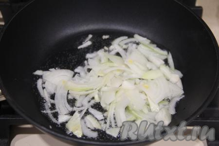 Пока тесто поднимается, приготовим начинку. Для этого очищенную луковицу нужно нарезать полукольцами (или четверть кольцами). В сковороду влить растительное масло, разогреть на достаточно сильном огне, затем выложить лук. Обжарить лук на среднем огне в течение 3-4 минут, не забывая иногда помешивать.