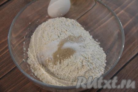 В миску всыпать 250 грамм просеянной муки, добавить дрожжи, соль и сахар, перемешать сухие ингредиенты.