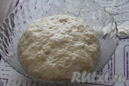 По истечении часа тесто поднимется, увеличившись в 2-3 раза, и округлится. Обмять тесто и переложить на поверхность, припылённую мукой.