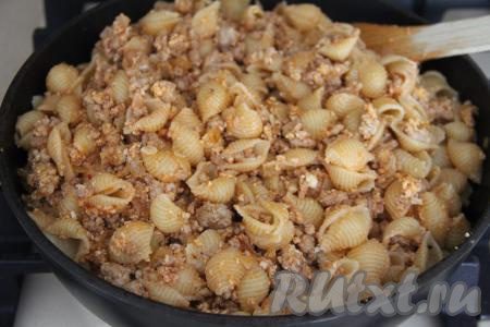 Добавить в сковороду к фаршу макароны и перемешать. Потомить пару минут, иногда перемешивая, чтобы макароны хорошо прогрелись.