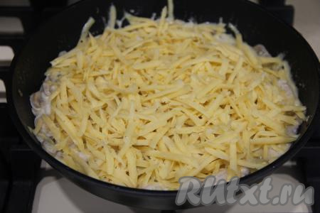 Убавить огонь до минимума. Посыпать жульен из курицы и грибов натёртым сыром.