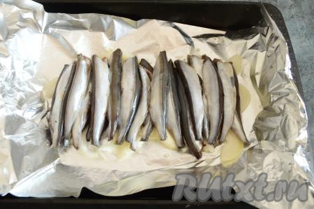 Мойву посолить, можно поперчить (или посыпать, например, приправами для рыбы), взбрызнуть лимонным соком. На луковую подушку равномерно выложить мойву.