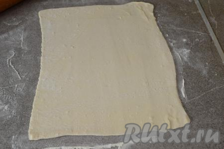 Слоёное тесто на присыпанной мукой поверхности раскатать в прямоугольник со сторонами примерно 30 на 35 сантиметров.