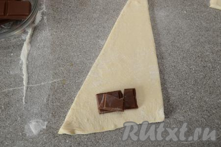 Ближе к самой узкой стороне треугольника выложить несколько кусочков шоколада (если вы не знаете, насколько хорошо плавится шоколад, который вы используете в выпечке, тогда нарежьте его на небольшие кусочки, я мелко нарезать не стала, потому что была уверена, что этот шоколад хорошо плавится).